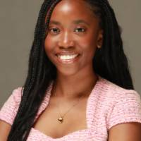 Woman posing for headshot with arms crossed, smiling